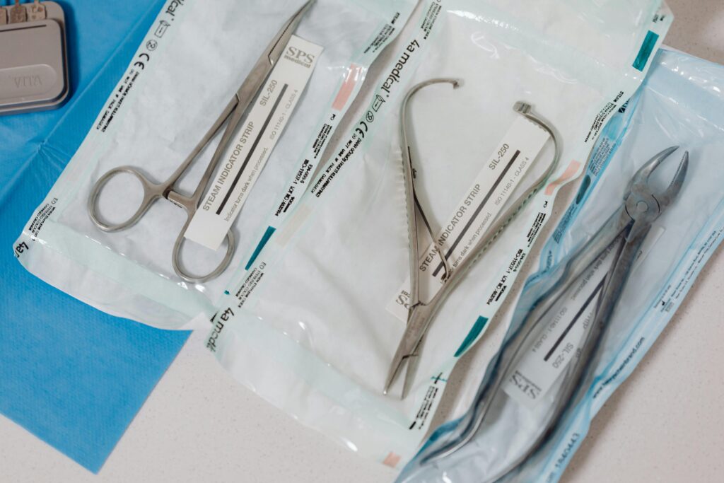 Close-up of sterilized surgical tools in packaging on a clinical table.